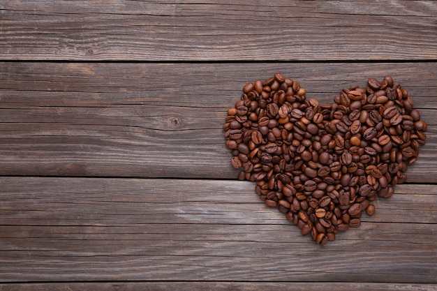 Chicchi di caffè a forma di cuore su sfondo grigio