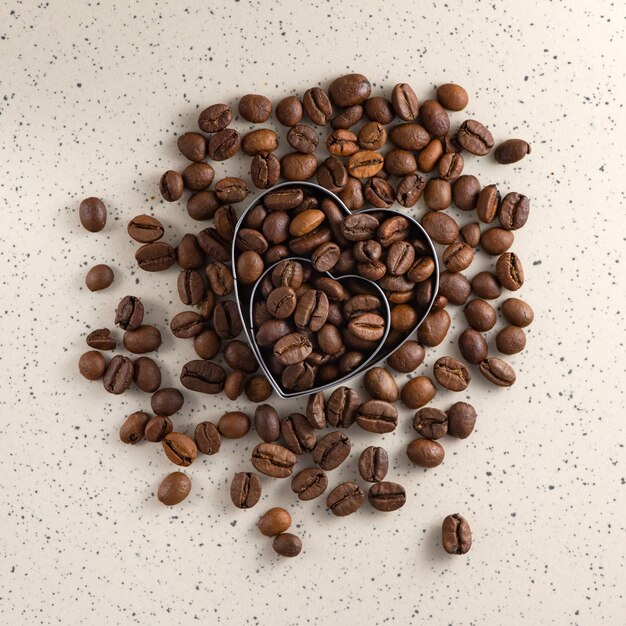 Coffee beans in the shape of a heart on light. Top view.