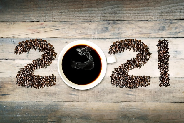 Photo coffee beans shaped 2021 numbers with hot coffee