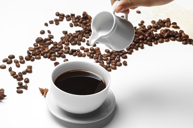 コーヒー豆とコーヒーでいっぱいの小さなカップ