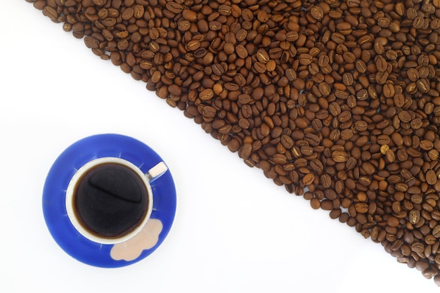 白い背景で隔離されたコーヒー豆のストライプ コーヒー豆と青いコーヒー カップのフレーム