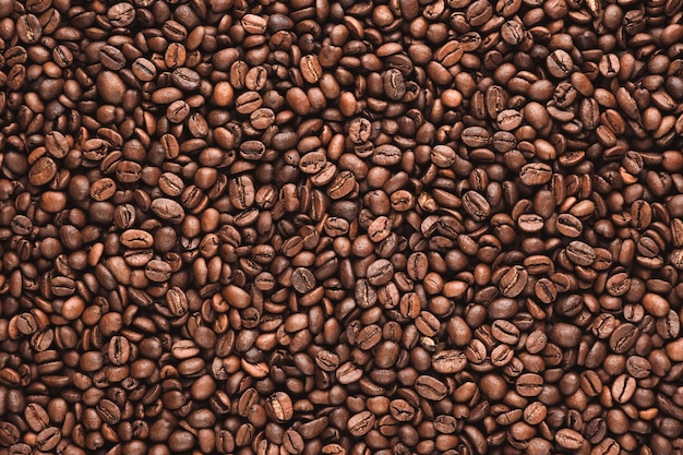 コーヒー豆のテクスチャまたはコーヒー豆の背景。茶色の焙煎コーヒー豆。コーヒー豆のクローズアップショット。多くのコーヒー豆。コーヒー豆は背景として使用できます。焼きたてのコーヒー豆。