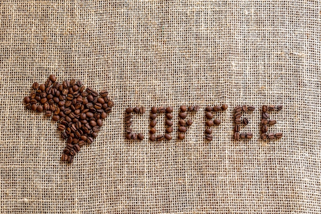 Coffee beans that form the map of Brazil and the word coffee top view and space for text