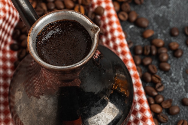 Coffee beans and turk on dark surface