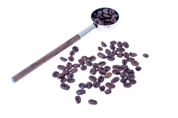 Coffee beans and vintage spoon on white surface