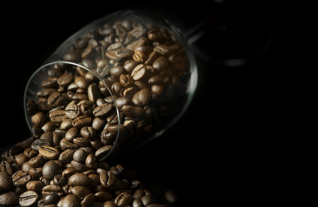 Coffee beans in wineglass on black background