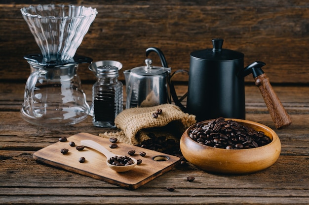 Chicchi di caffè con caffè americano accessorio sul tavolo di legno