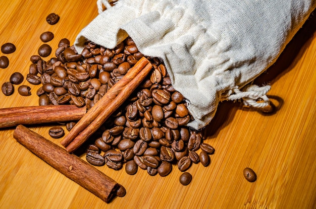 木製の背景にシナモンとコーヒー豆。