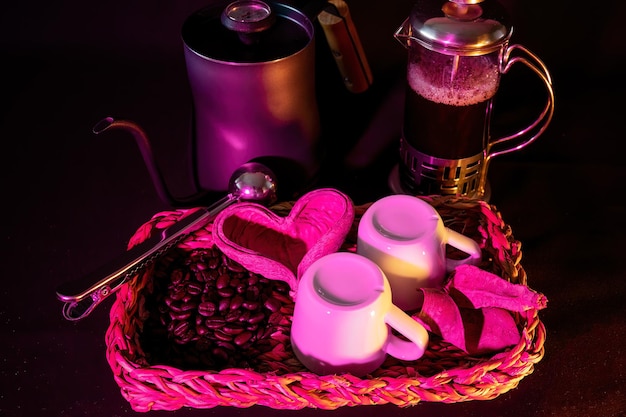 Кофейные зерна с кофейным сервизом, деревянным сердцем и розовым светом