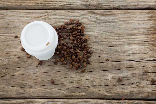 Photo coffee beans with disposable coffee cup