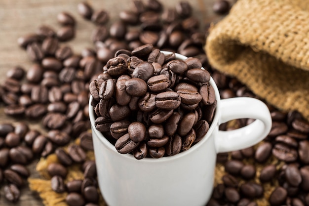 coffee beans with white cup on wooden table