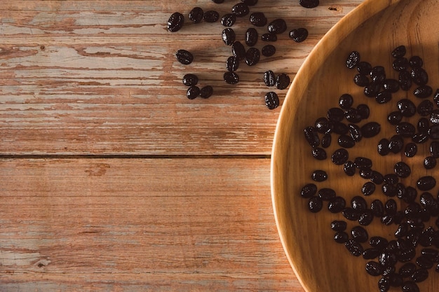 Coffee beans on wooden plate and vintage wood surface Copy space Selective focus