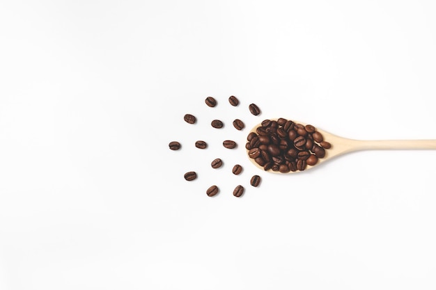 Photo coffee beans on wooden spoon in flat lay