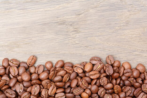 Coffee beans on wooden table texture with copy space View from