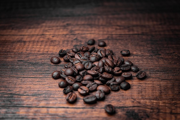 Coffee beans on a wooden table with a dark background.