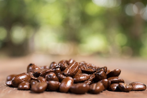 Coffee beans on wooden texture.