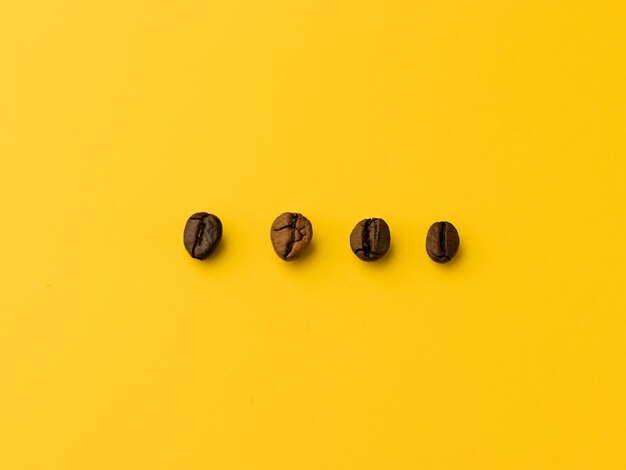 Coffee beans on yellow background