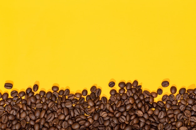 Coffee beans on yellow surface