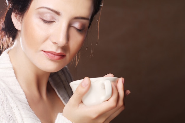 コーヒー。お茶やコーヒーを飲む美しい少女。温かい飲み物のカップ