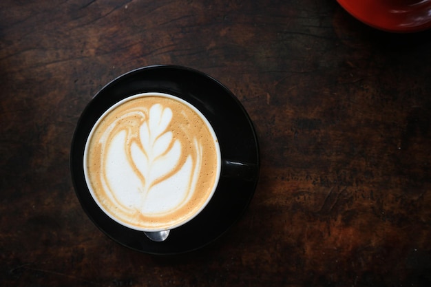 Coffee in black cup on old grunge dark textured wooden background