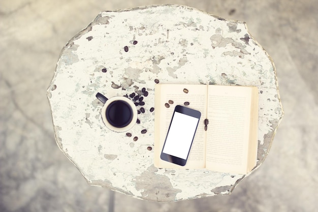 Coffee blank cell phone and a book on the table