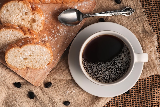 フローリングのコーヒーとパン、朝の飲み物と朝食。上面図