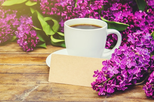 Coffee for Breakfast and lilac flowers. Selective focus.