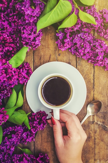 朝食用コーヒーとライラック色の花。セレクティブフォーカス