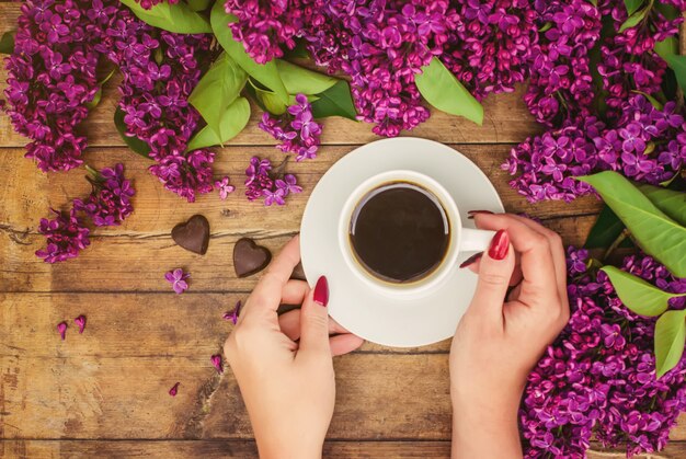 朝食用コーヒーとライラック色の花。セレクティブフォーカス