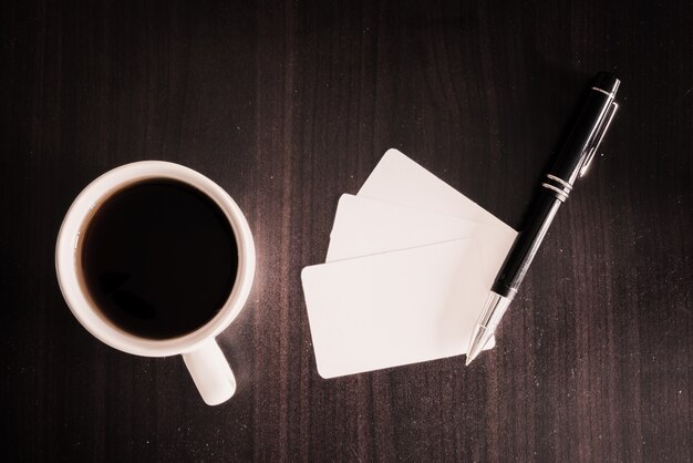 coffee and business card and pen on wooden background. Business concept