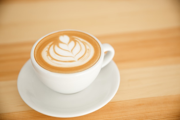 Coffee business concept - fresh serve hot coffee with heart latte art in modern coffee shop