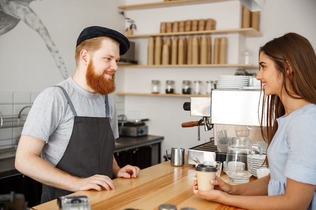 コーヒービジネスコンセプト - 現代のコーヒーショップで美しいコーカサスの顧客と話す若い裸のハンサムなバーディスタ。