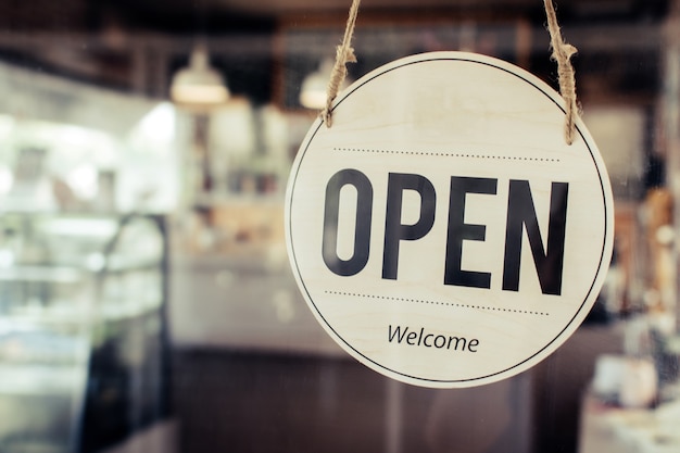 Photo coffee cafe shop text on vintage sign board hanging on glass door in modern cafe shop