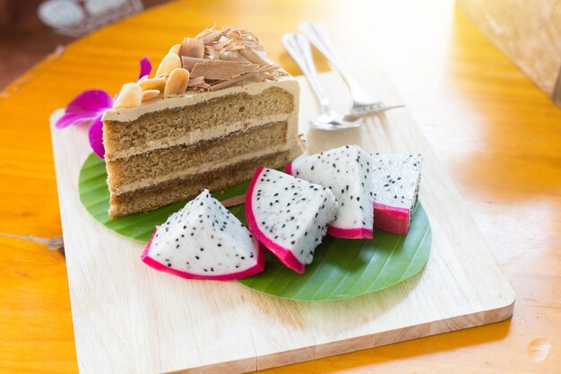Coffee cake topped with chocolate and almonds decorated with banana leaf dragon fruit and orchid
