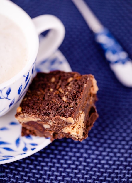 Coffee cappuccino and a piece of brownie with peanut butter