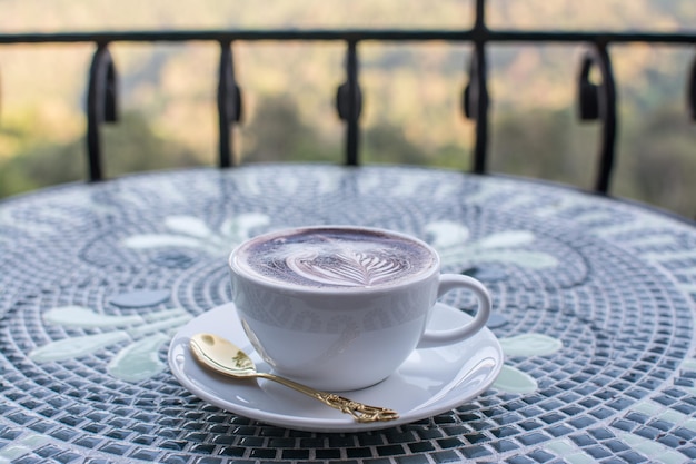 自然の背景を持つテーブルの上のコーヒー カプチーノ