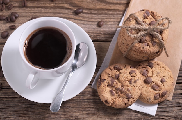 Coffee and chocolate cookies on wooden table