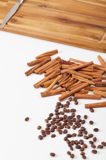 Coffee and cinnamon spices scattered on a white board, natural food