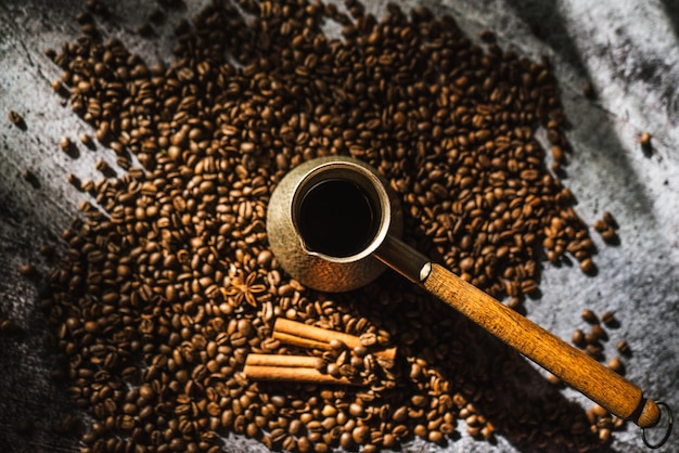 Coffee cinnamon sticks and spices on brown wooden board