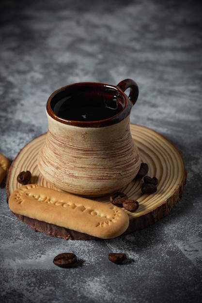 Coffee in a clay cup and cookies on an abstract background