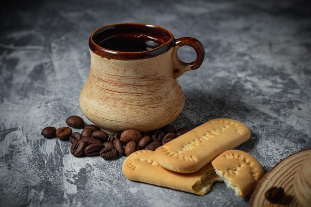 抽象的な背景に粘土のカップとクッキーのコーヒー