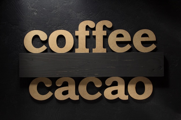 Coffee and cocoa letters on black surface