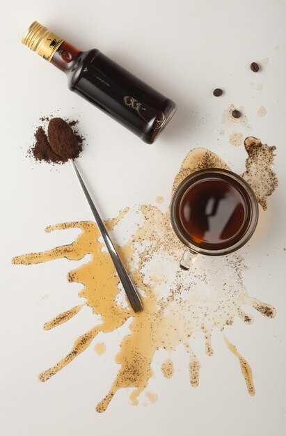 Coffee concept with coffee in cup, coffee beans and irish cream syrup isolated on white