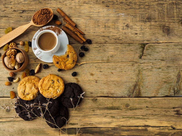 Coffee, cookies and nuts on a wooden table. Space for text on the table.