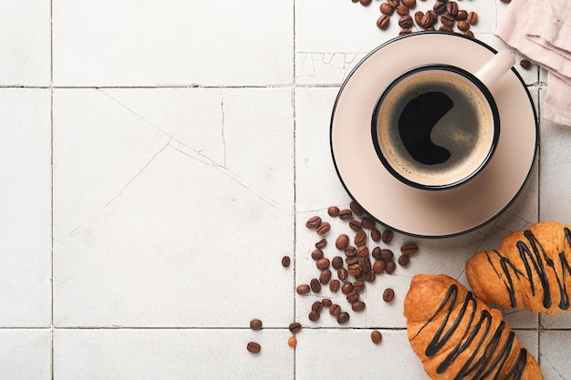 コーヒーとクロワッサンエスプレッソコーヒーとチョコレートとクロワッサン古いひびの入ったタイルテーブル朝の完璧なクロワッサン朝食素朴なスタイル上面図モックアップ