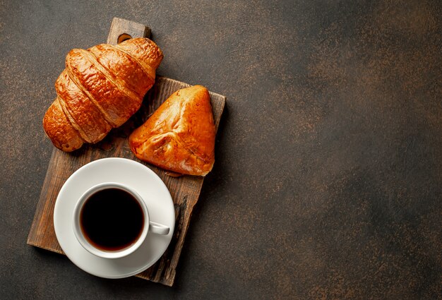 Coffee and croissant on a stone background. tasty breakfast   with copy space for your text