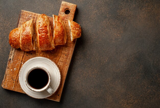 Coffee and croissant on a stone background. tasty breakfast  with copy space for your text