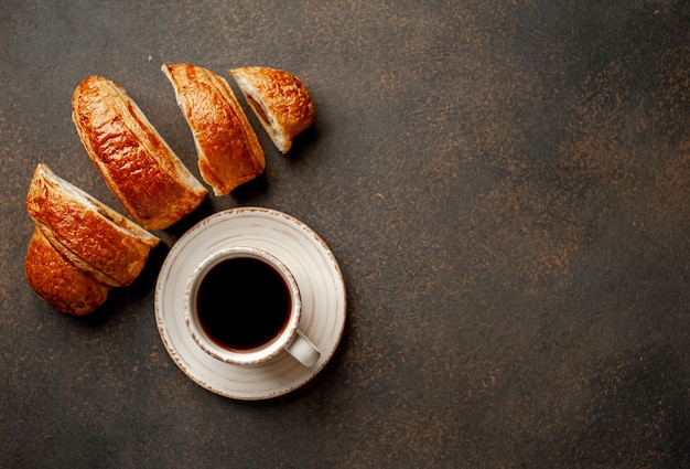 Coffee and croissant on a stone background. tasty breakfast  with copy space for your text