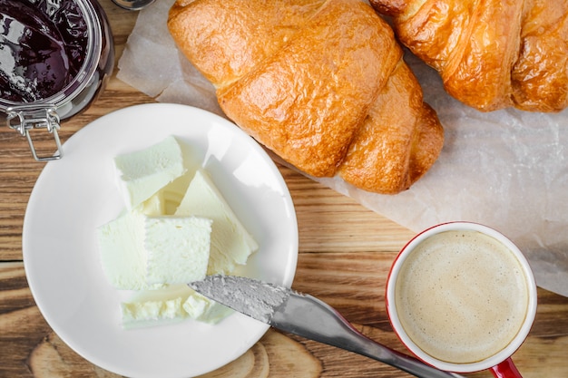 Coffee, croissants, butter and jam, top view