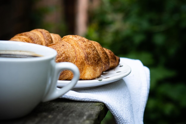 Coffee and croissants on old rustic wooden table